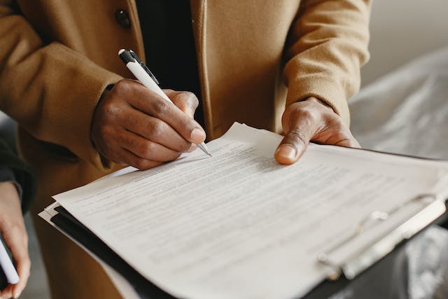 person holding a clipboard with a lease agreement on it